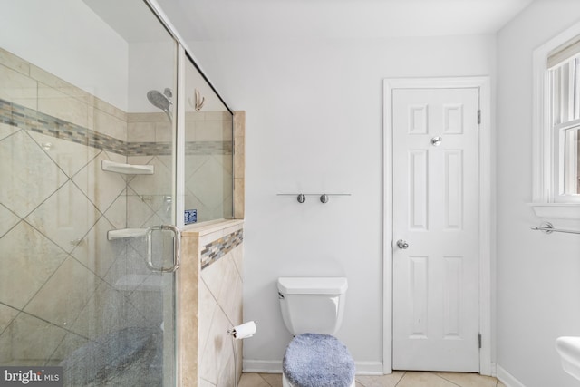 bathroom with tile patterned floors, a shower with shower door, and toilet