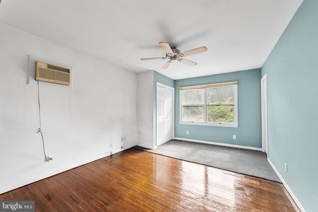 spare room with ceiling fan, wood-type flooring, and an AC wall unit