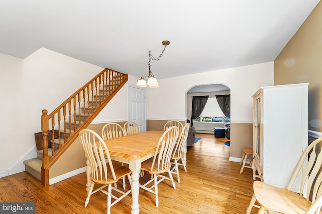 dining area featuring light wood-type flooring and a chandelier