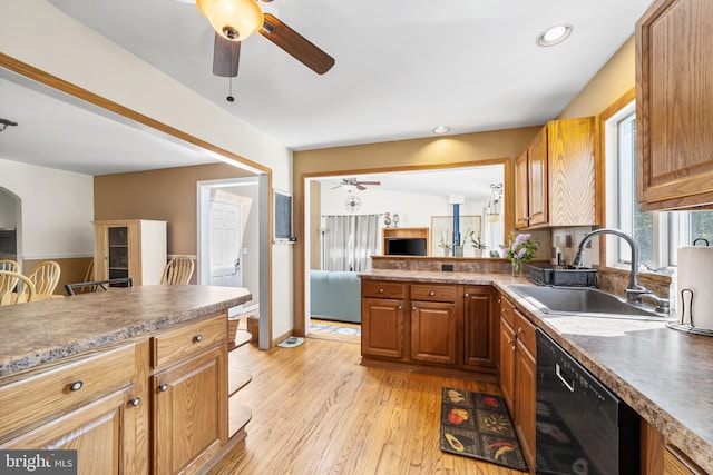 kitchen featuring black dishwasher, sink, ceiling fan, and light hardwood / wood-style flooring