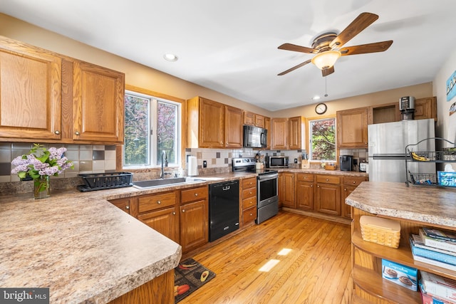 kitchen with black appliances, tasteful backsplash, sink, and plenty of natural light