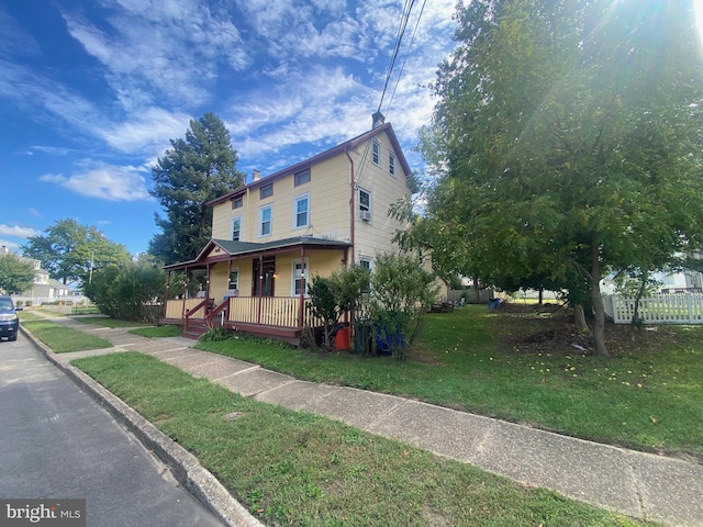 view of home's exterior with a yard and a porch