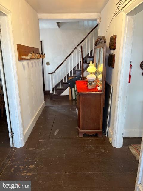 hallway featuring stairway and baseboards