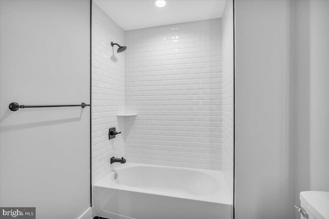 bathroom with tiled shower / bath combo and toilet