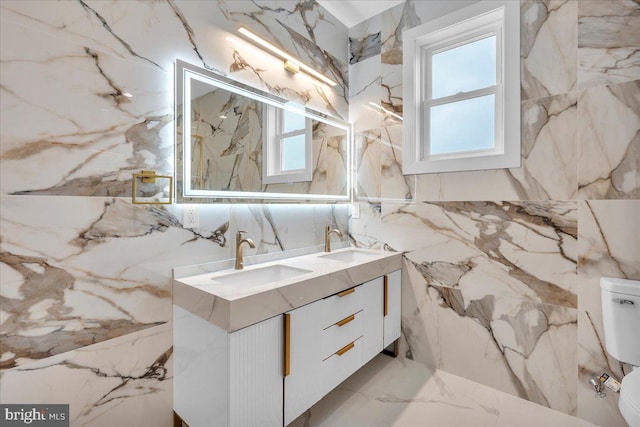 bathroom with vanity, a healthy amount of sunlight, toilet, and tile walls