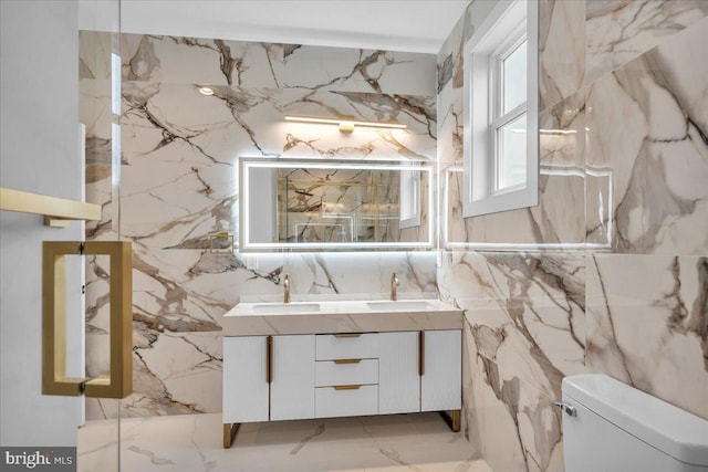 bathroom featuring vanity, tile walls, and toilet