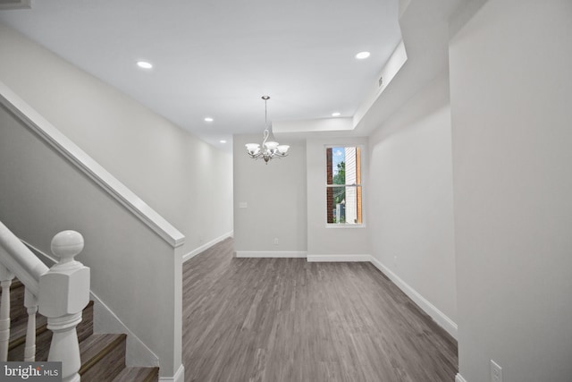 spare room with a notable chandelier and hardwood / wood-style floors