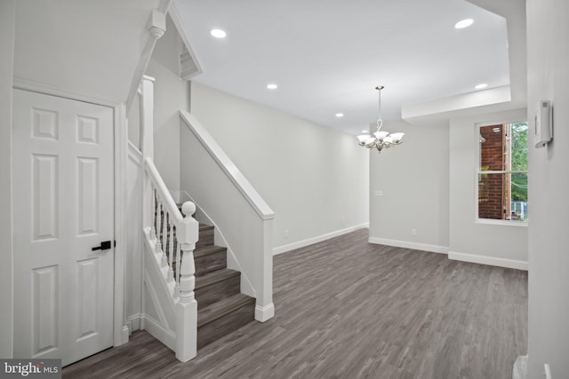 stairs with an inviting chandelier and wood-type flooring