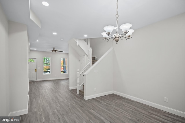 interior space featuring ceiling fan with notable chandelier and dark wood-type flooring