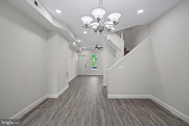 foyer entrance with ceiling fan with notable chandelier and dark hardwood / wood-style floors