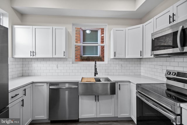 kitchen with dark wood-type flooring, tasteful backsplash, sink, white cabinetry, and stainless steel appliances