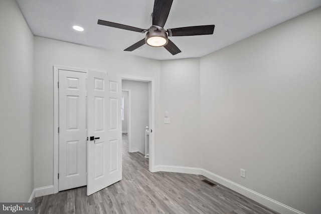 unfurnished bedroom with ceiling fan, light hardwood / wood-style flooring, and a closet