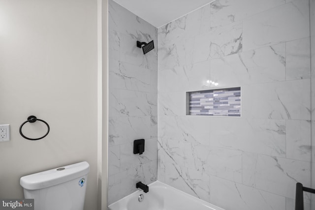 bathroom featuring toilet and tiled shower / bath