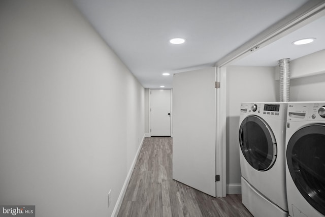 clothes washing area featuring hardwood / wood-style floors and independent washer and dryer