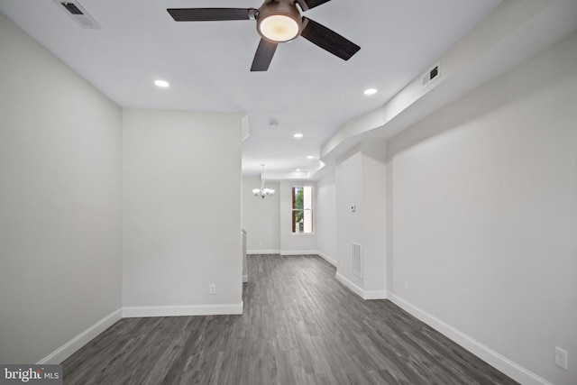 unfurnished room featuring ceiling fan with notable chandelier and dark hardwood / wood-style floors