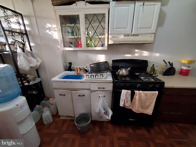 kitchen with white cabinets, dark parquet floors, black range with gas cooktop, and sink