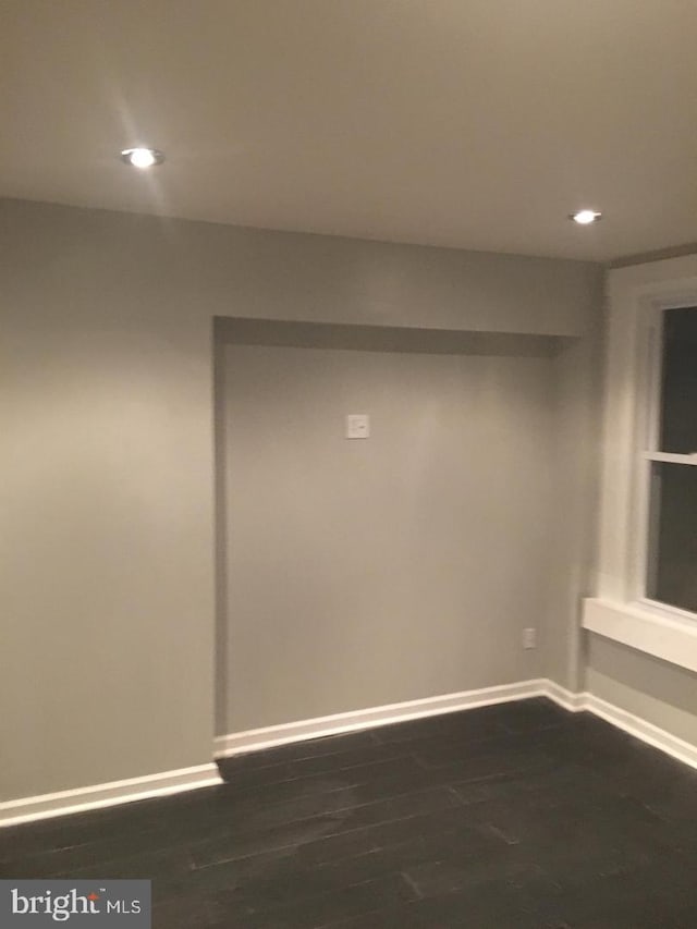 empty room with dark hardwood / wood-style flooring