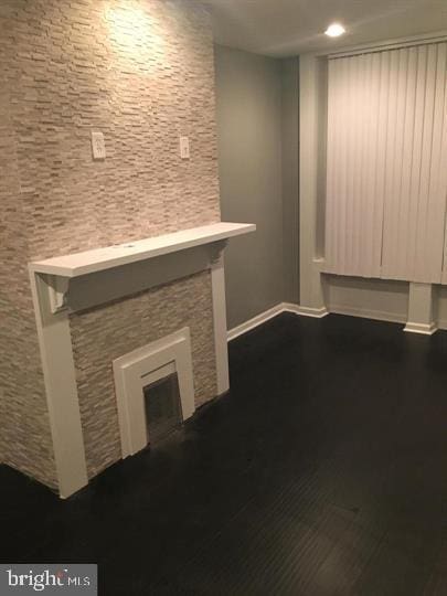 unfurnished living room with a fireplace and dark hardwood / wood-style flooring