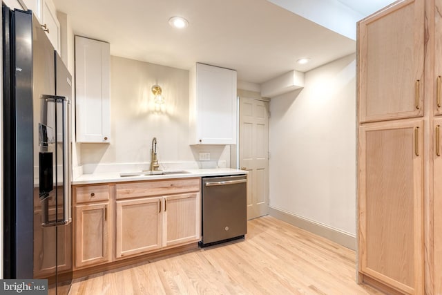 kitchen with light brown cabinets, sink, stainless steel appliances, and light hardwood / wood-style flooring