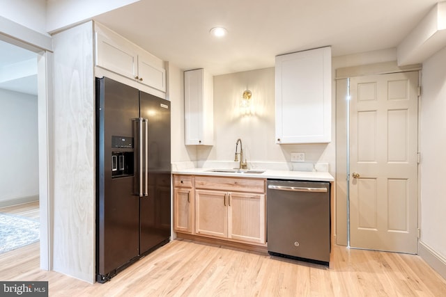 kitchen with light brown cabinetry, light hardwood / wood-style flooring, sink, white cabinets, and appliances with stainless steel finishes