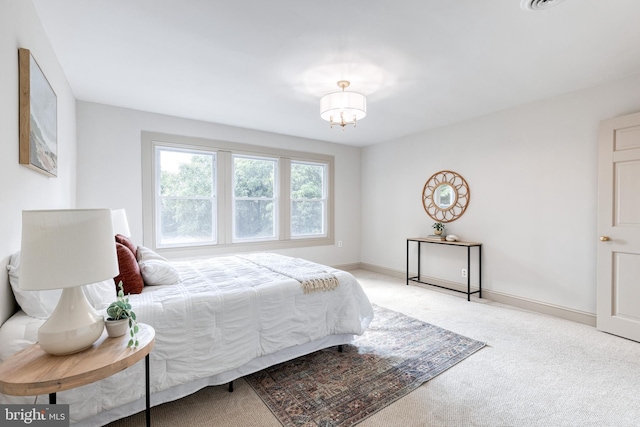 bedroom featuring a chandelier and light carpet