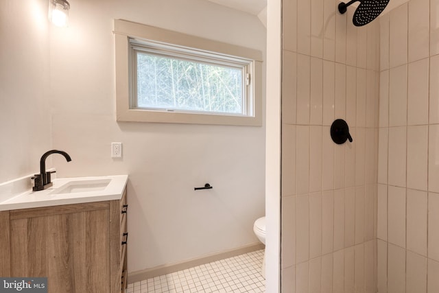 bathroom with tile patterned flooring, a tile shower, vanity, and toilet