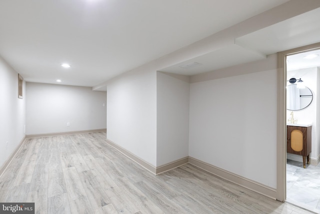 basement with light hardwood / wood-style floors