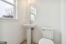 bathroom with plenty of natural light and toilet