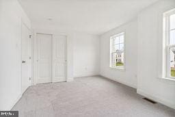 unfurnished bedroom featuring light carpet