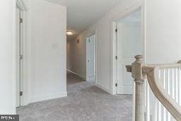 hallway with light colored carpet