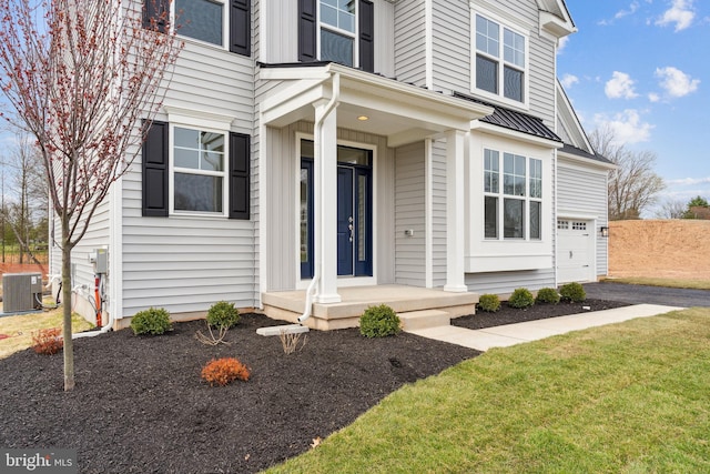 view of front of house with central AC unit, a garage, and a front lawn