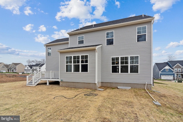 rear view of property with a wooden deck and a yard