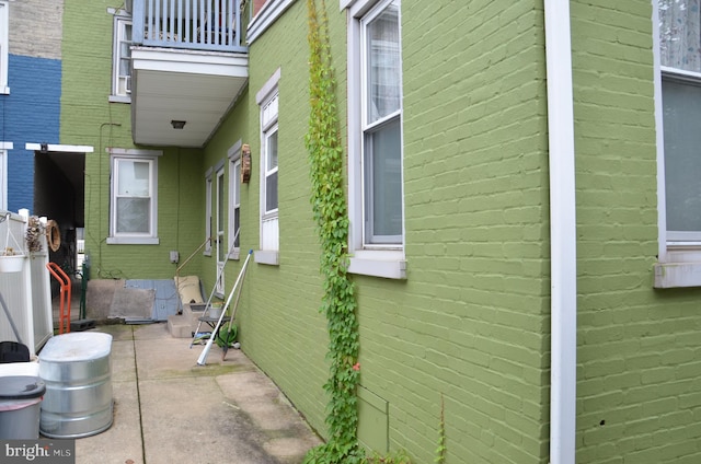 view of side of property with a balcony and a patio area