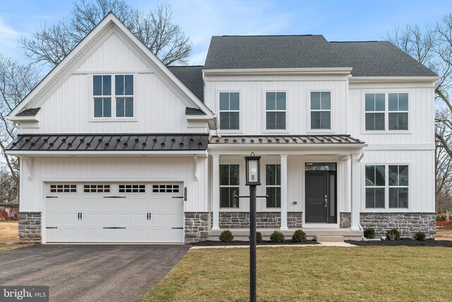 modern farmhouse featuring a front lawn and a garage