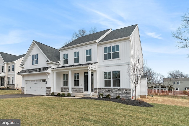 view of front of house featuring covered porch, a front yard, and a garage