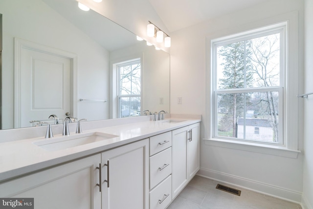 bathroom featuring tile patterned flooring, vaulted ceiling, and vanity