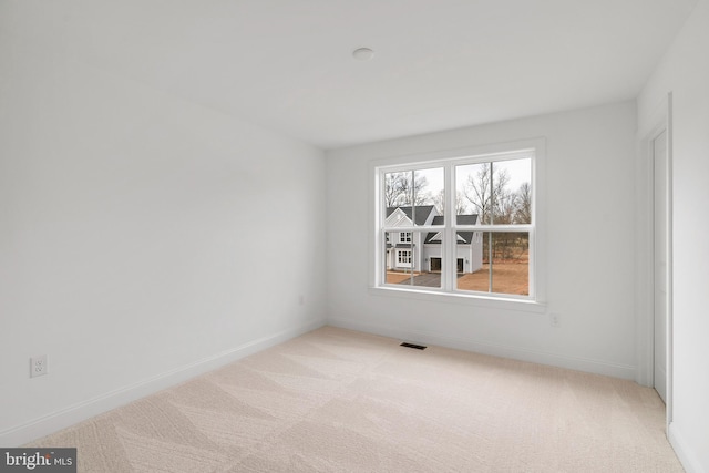 unfurnished room featuring light colored carpet