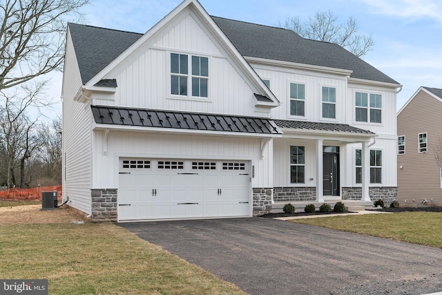 view of front facade with central AC, a garage, and a front yard