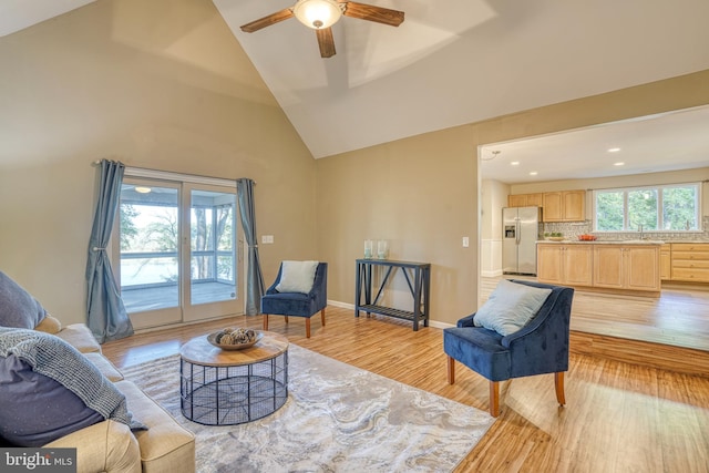 living room featuring sink, ceiling fan, light hardwood / wood-style floors, and plenty of natural light