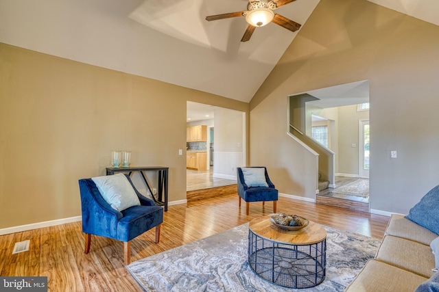 living room with high vaulted ceiling, light wood-type flooring, and ceiling fan