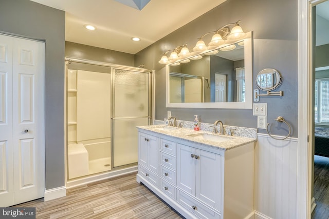 bathroom with vanity, hardwood / wood-style flooring, and a shower with shower door