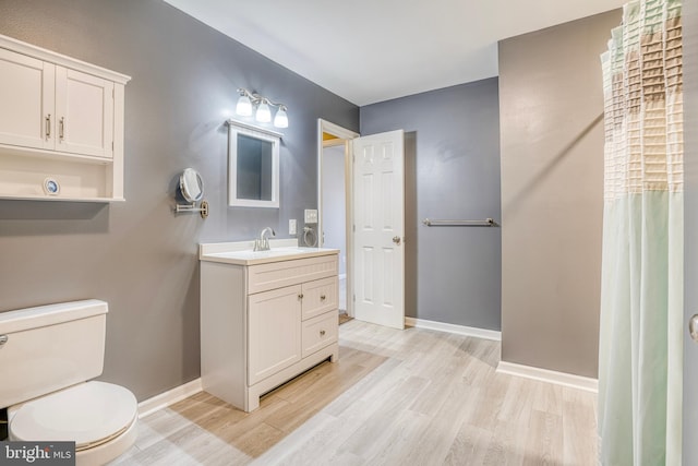 bathroom with vanity, wood-type flooring, and toilet