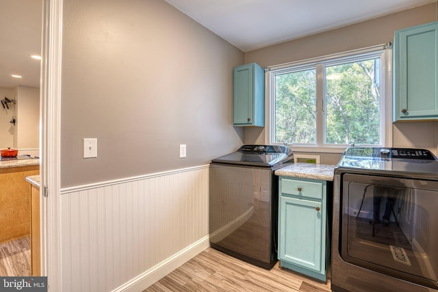 laundry area with cabinets, independent washer and dryer, and light wood-type flooring