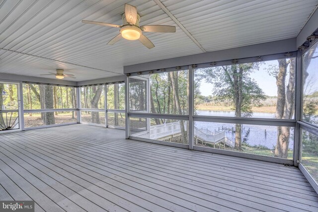 unfurnished sunroom featuring a water view, ceiling fan, and plenty of natural light