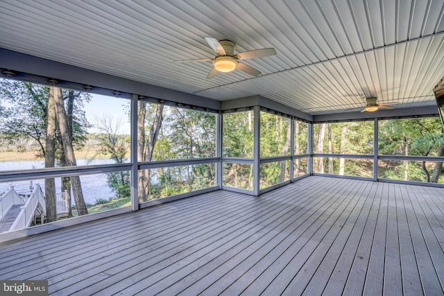 unfurnished sunroom with a water view and ceiling fan