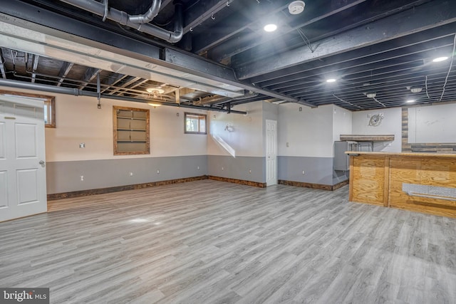 basement with light hardwood / wood-style flooring