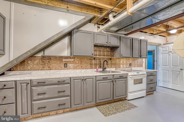 kitchen with sink, tasteful backsplash, white range oven, and gray cabinetry