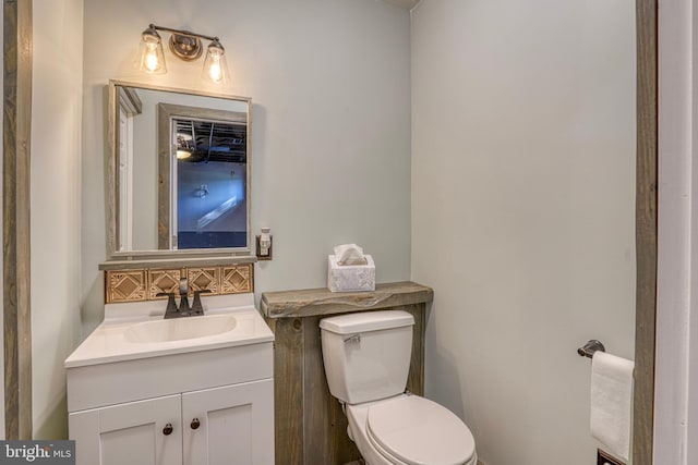 bathroom with toilet, tasteful backsplash, and vanity