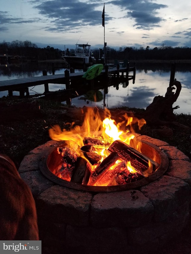 exterior space featuring a water view and a fire pit