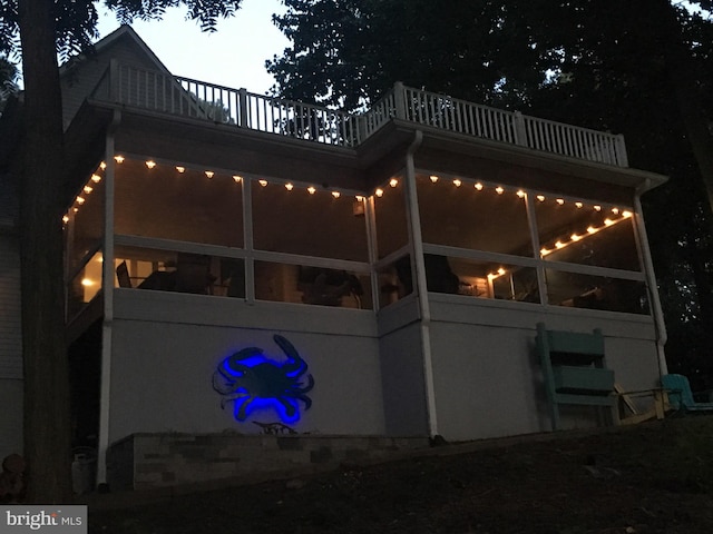 back of property featuring a balcony and a sunroom